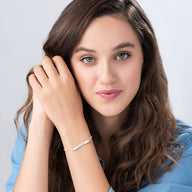 Bracelet gourmette en argent sterling fin orné d'oxydes de zirconium porté sur poignet féminin.