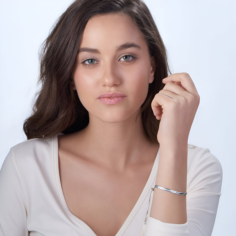 Bracelet gourmette en argent sterling lisse porté au poignet féminin, style minimaliste élégant.