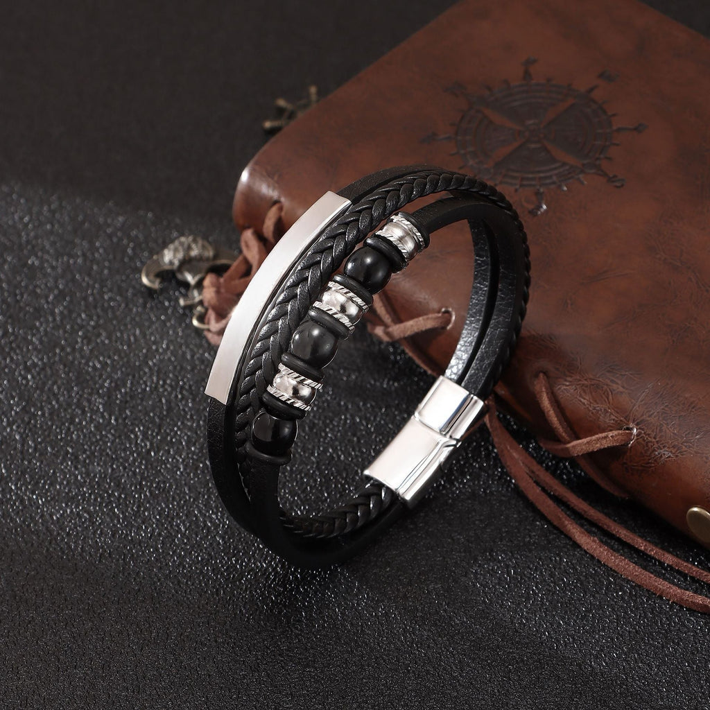 Bracelet homme multi-rangs en cuir noir avec perles onyx noires et fermoir magnétique argenté, plaque gravée.