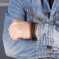 Bracelet homme en cuir tressé noir et perles en bois marron avec fermoir magnétique, style naturel urbain.