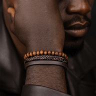 Bracelet homme avec cuir tressé noir, perles en bois clair, et cuir lisse marron, fermoir magnétique.