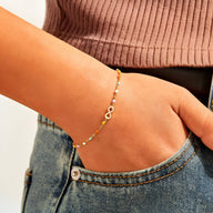 Bracelet infini en or avec perles multicolores, style délicat pour femme.