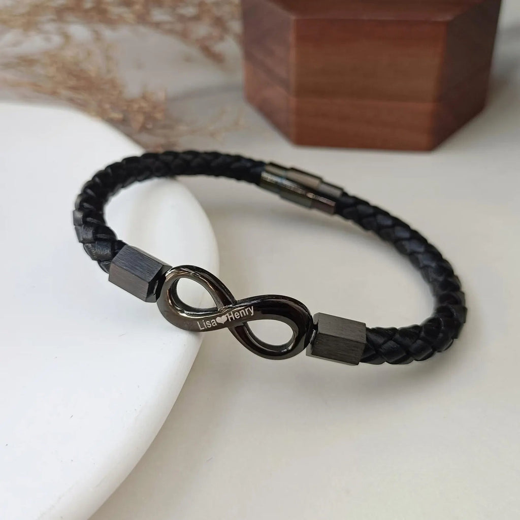 Bracelet en cuir tressé noir avec ornement infini en métal gris foncé brillant et fermoir magnétique gris anthracite.