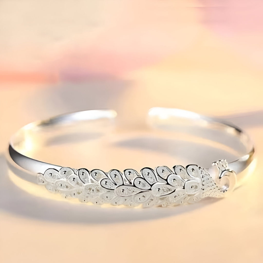 Bracelet jonc argent sterling avec gravure détaillée d’un paon stylisé pour femme.