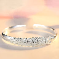 Bracelet jonc argent sterling avec gravure détaillée d’un paon stylisé pour femme.