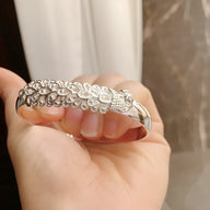 Bracelet jonc en argent sterling avec motif paon détaillé et texturé, finition brillante.