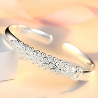 Bracelet jonc en argent sterling avec motif paon délicat et détails gravés élégants.