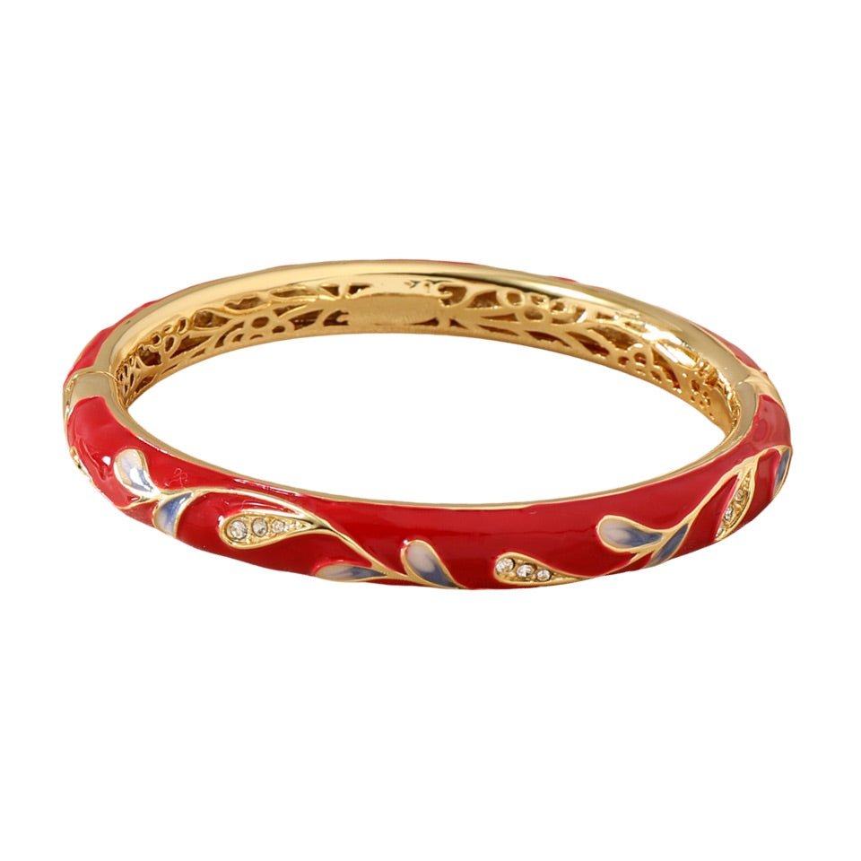Bracelet jonc rouge en cuivre plaqué or avec motif floral délicat et détails scintillants.