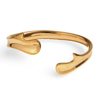 Bracelet jonc ouvert doré en acier inoxydable avec design fluide et moderne.