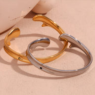 Bracelets joncs ouverts modernes en acier inoxydable, finition argent et or, design épuré et lisse.