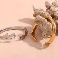 Bracelet jonc ouvert en acier inoxydable finition argentée avec design ondulé moderne  .