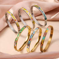 Six bracelets joncs émaillés aux motifs colorés variés, finition or et argent, style distinctif femme.