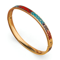 Bracelet jonc en métal doré avec émail coloré bleu, rouge et beige et motifs géométriques distinctifs.