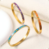 Bracelet jonc doré émaillé motifs colorés bleu, orange et violet pour femme.