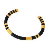 Bracelet jonc titane noir avec détails dorés rayés, style moderne et épuré.