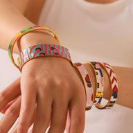 Bracelet jonc émaillé coloré aux formes abstraites avec motifs géométriques et lignes fluides.