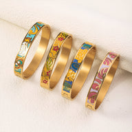 Quatre bracelets joncs dorés émaillés avec motifs floraux colorés variés, style délicat féminin.