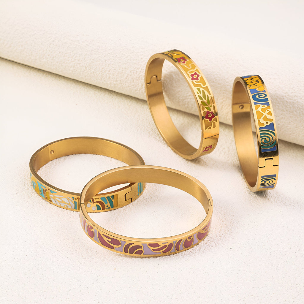 Lot de quatre bracelets joncs en métal doré avec motifs émaillés colorés variés, style délicat féminin.