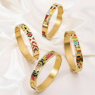 Quatre bracelets joncs en métal doré émaillé avec motifs géométriques et couleurs vives variées.