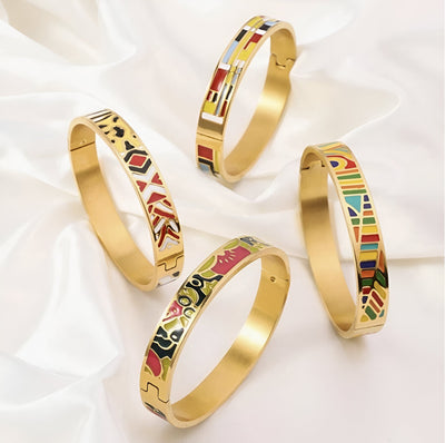 Quatre bracelets joncs en métal doré émaillé avec motifs géométriques et couleurs vives variées.