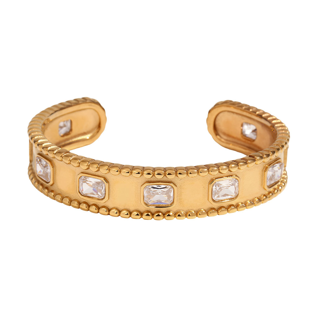Bracelet jonc doré en acier inoxydable avec pierres rectangulaires et bordure perlée.