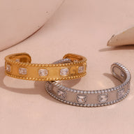 Bracelet jonc en acier inoxydable doré à pierres carrées et détails perlés, modèle Sohan; variante argentée similaire.