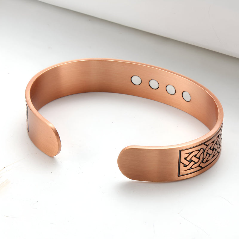Bracelet jonc en cuivre couleur bronze avec motif celtique gravé et aimants visibles à l'intérieur.
