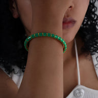Bracelet jonc vert en titane et acrylique aux maillons rectangulaires sur poignet féminin.