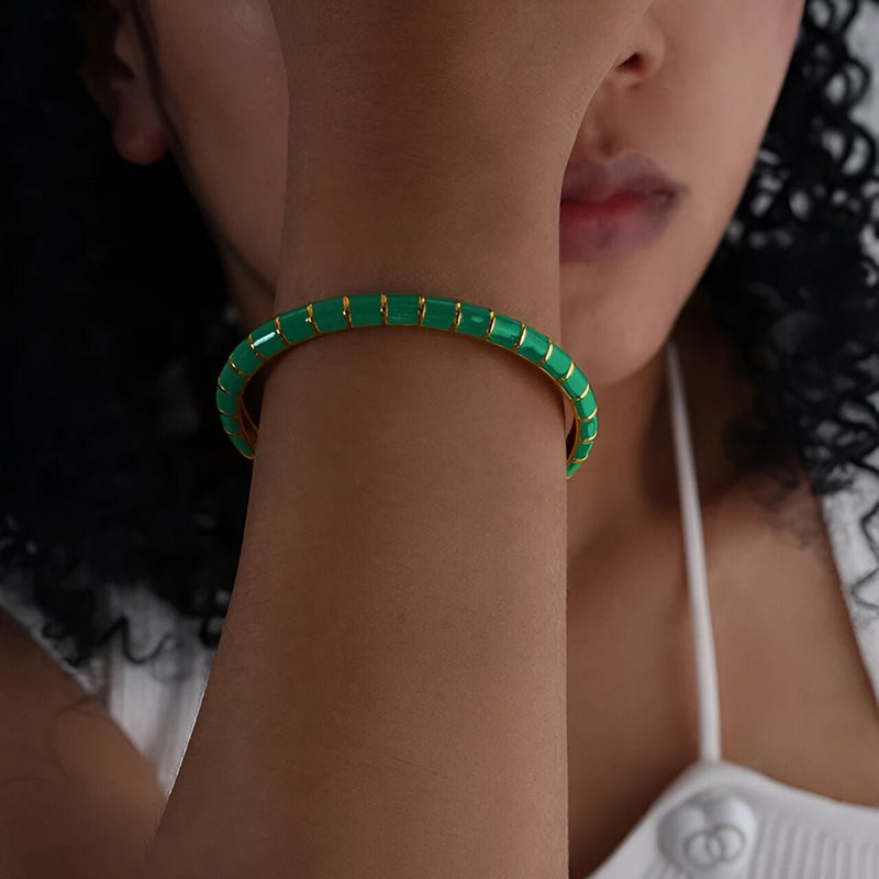 Bracelet jonc vert en titane et acrylique aux maillons rectangulaires sur poignet féminin.