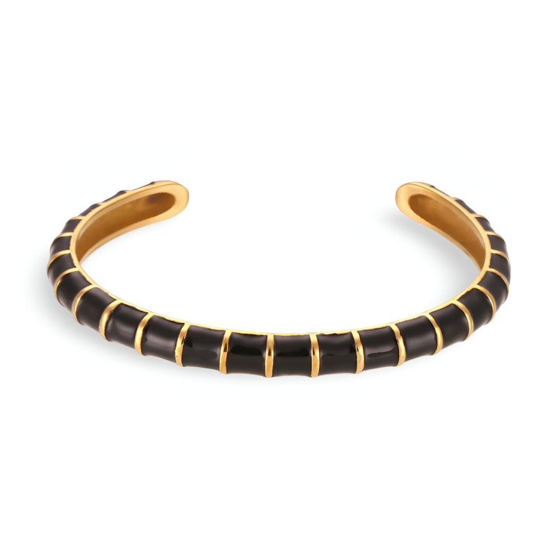 Bracelet jonc en titane avec sections noires et séparateurs dorés, style moderne et épuré.