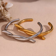 Deux bracelets joncs en acier inoxydable, modèle Amara, demi nœud, finition or et argent, style minimaliste.