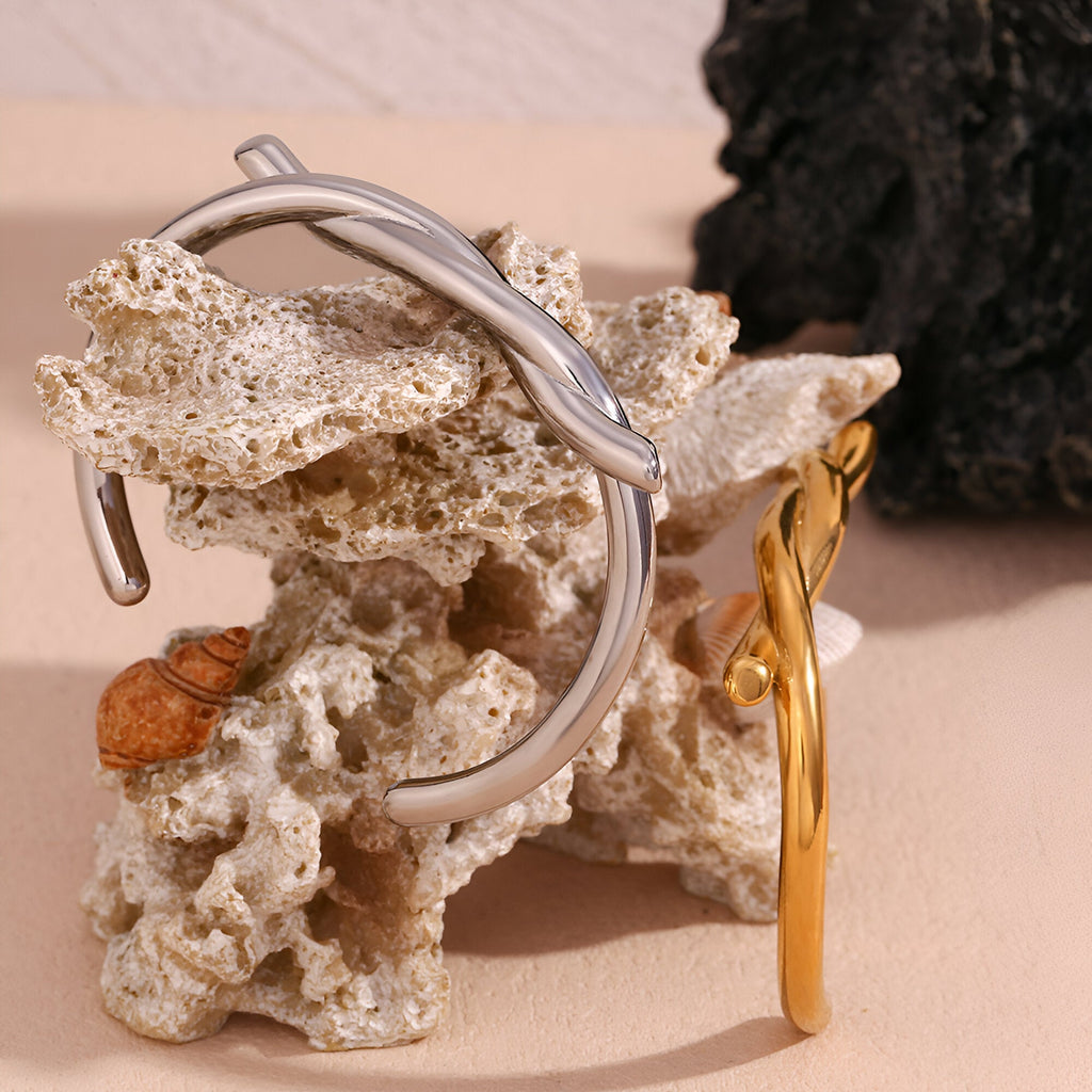 Bracelet jonc demi nœud en acier inoxydable finition argent, design moderne et épuré.