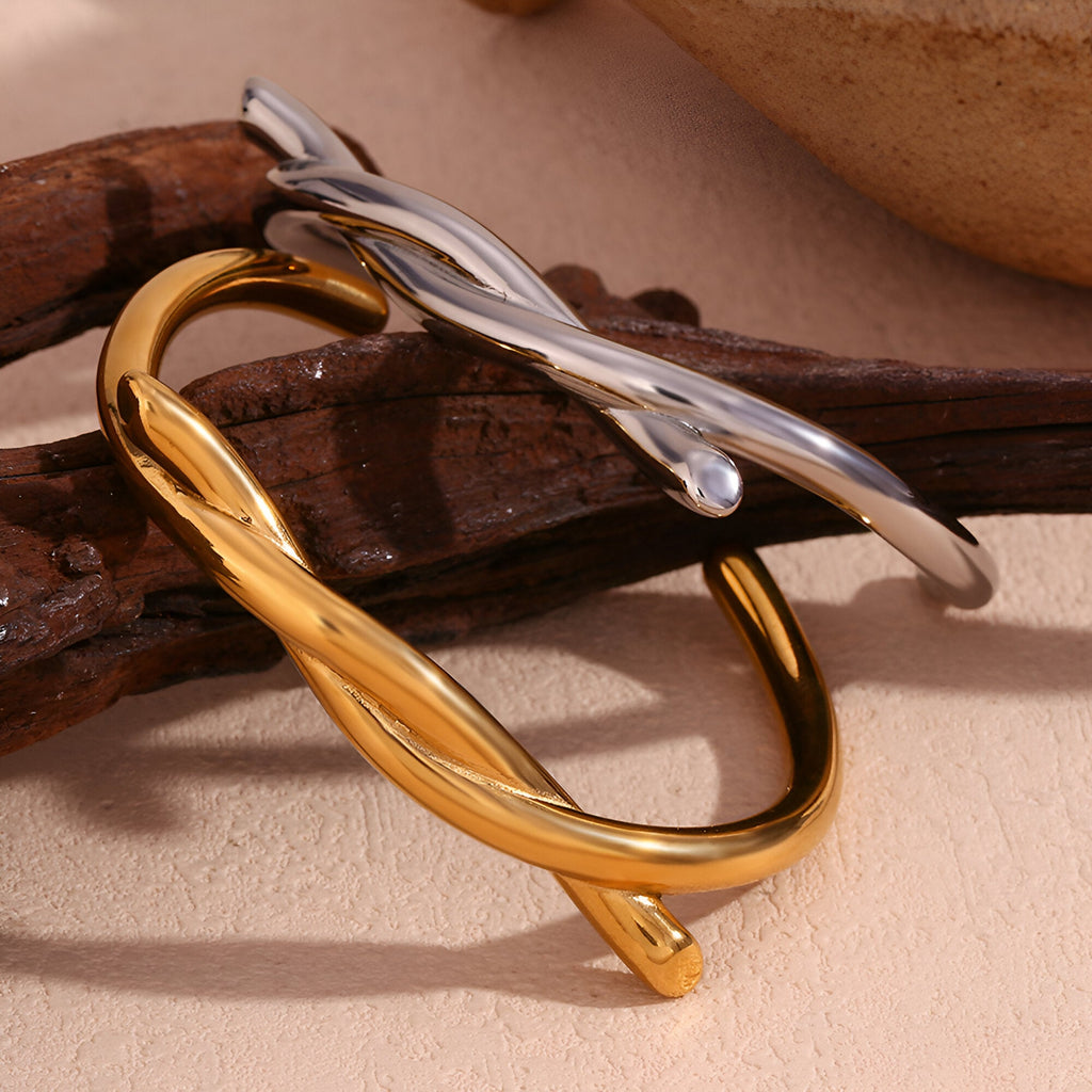 Bracelet jonc demi nœud en acier inoxydable, finition or brillant et argent lisse, design torsadé élégant.