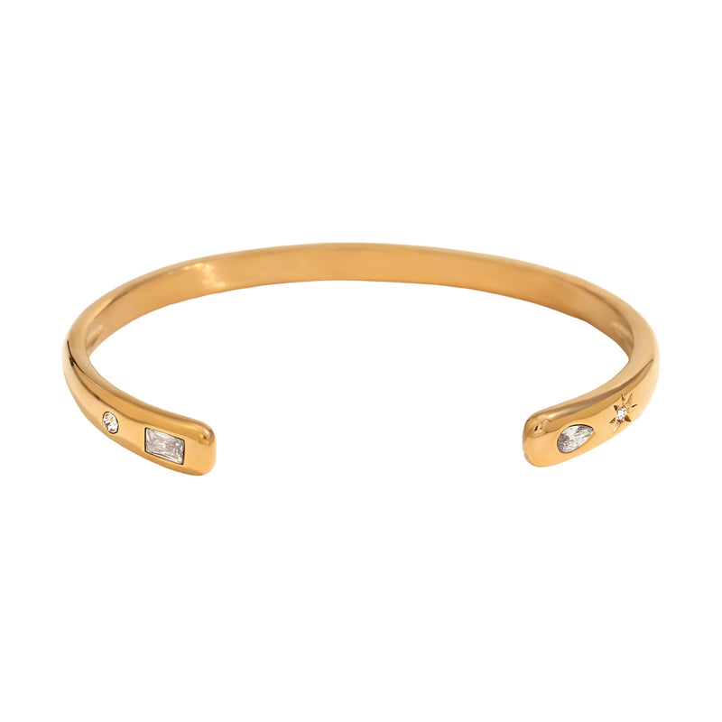 Bracelet jonc fin en acier inoxydable doré avec incrustations de petites pierres brillantes.