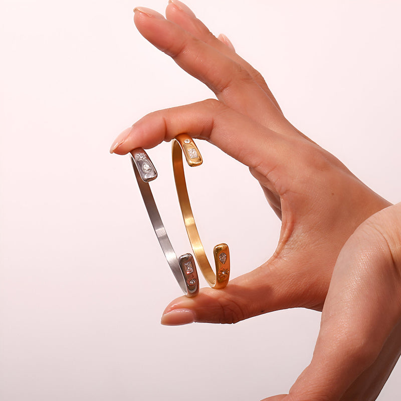 Bracelets jonc Hélios en acier inoxydable, finitions or et argent avec détails gravés étoiles.