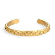 Bracelet jonc en acier inoxydable doré avec motifs célestes gravés et finition polie.