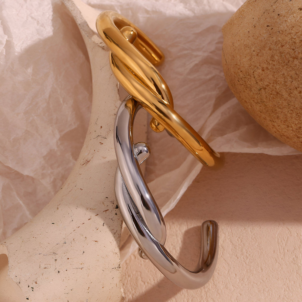 Bracelet jonc entrelacé en acier inoxydable, finition argent et or, design moderne et élégant.