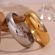 Bracelet jonc large en acier inoxydable poli, finition or brillant et argenté lisse.