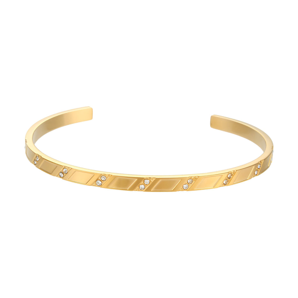 Bracelet jonc doré en acier inoxydable avec motif géométrique et petits cristaux intégrés.