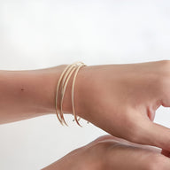 Bracelet jonc fin en acier inoxydable doré, design minimaliste et élégant.