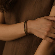 Bracelet jonc double en cuivre or vieux, finition antique, porté sur poignet, style mixte, design épuré.