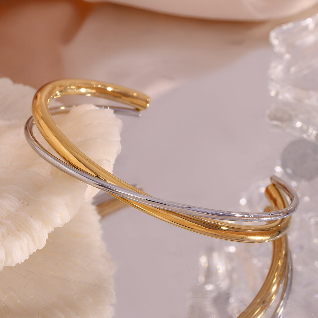 Bracelet jonc duo torsadé en acier inoxydable, finition or et argent, design élégant et minimaliste.