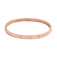 Bracelet jonc en acier inoxydable or rosé avec éclats de lumière sertis circulaires.