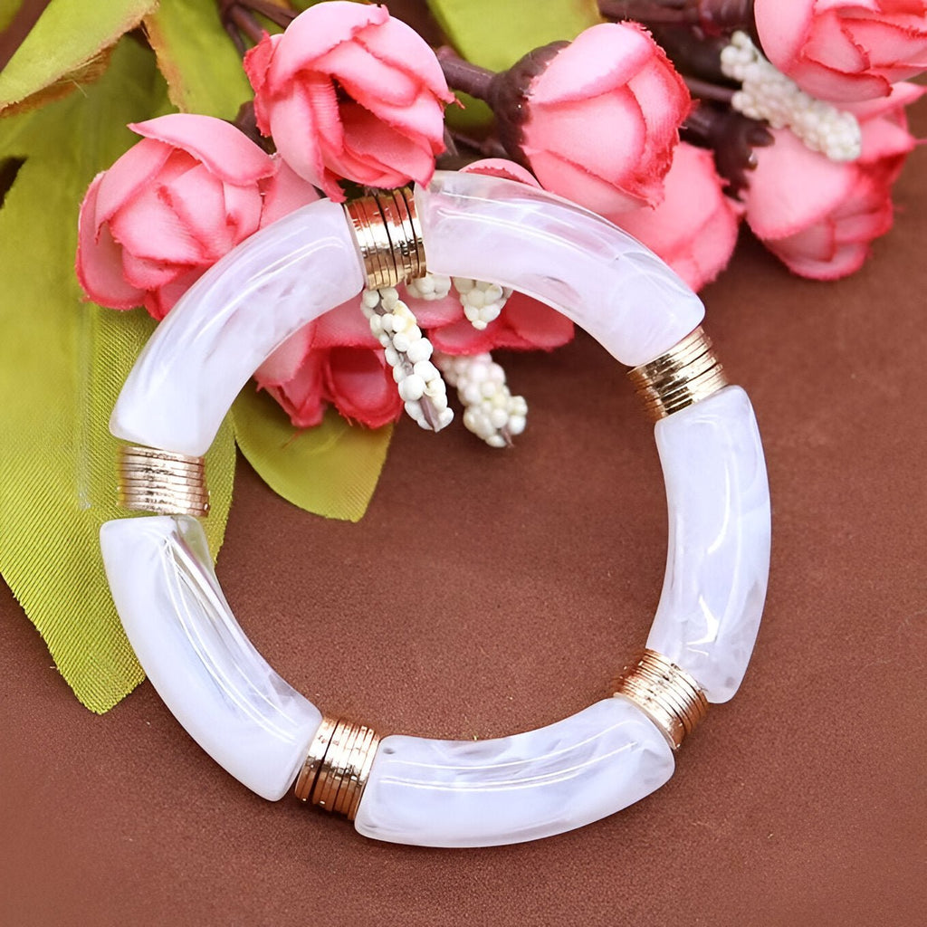 Bracelet jonc Emilia en acrylique blanc translucide avec anneaux dorés élégants.