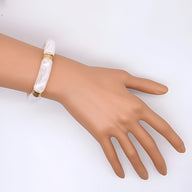 Bracelet jonc en acrylique blanc nacré, design épuré et moderne pour femme.