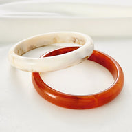 Bracelet jonc en acrylique blanc marbré et orange brillant, style élégant pour femme.