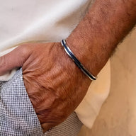 Bracelet jonc homme en acier inoxydable argenté avec corde bleue intégrée, style minimaliste.