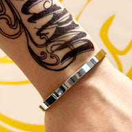 Bracelet jonc en acier inoxydable argenté, finition lisse et brillante, style moderne pour homme.