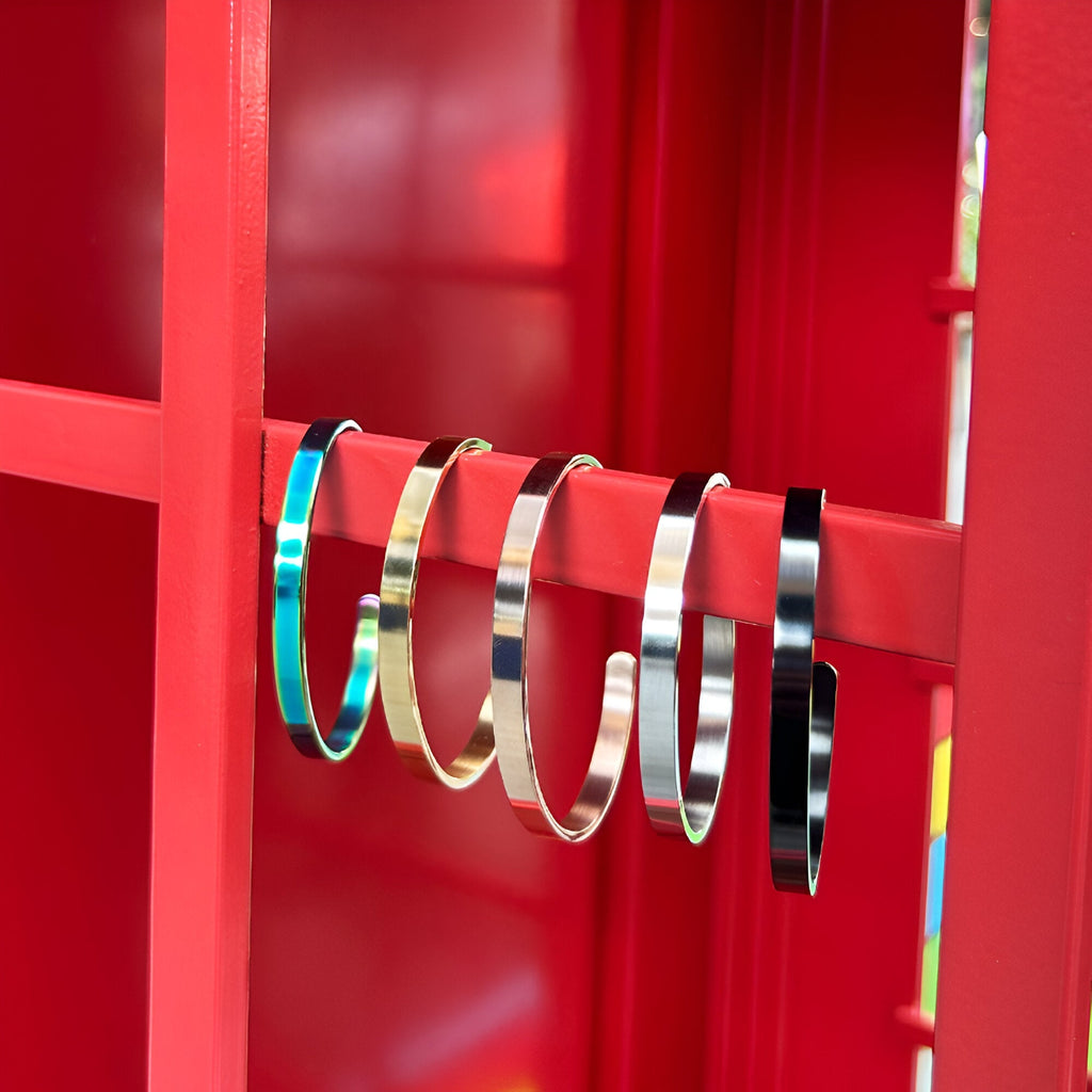 Bracelet jonc en acier inoxydable fin, couleurs or rosé, or jaune, argent, noir, et arc-en-ciel, design épuré et moderne.