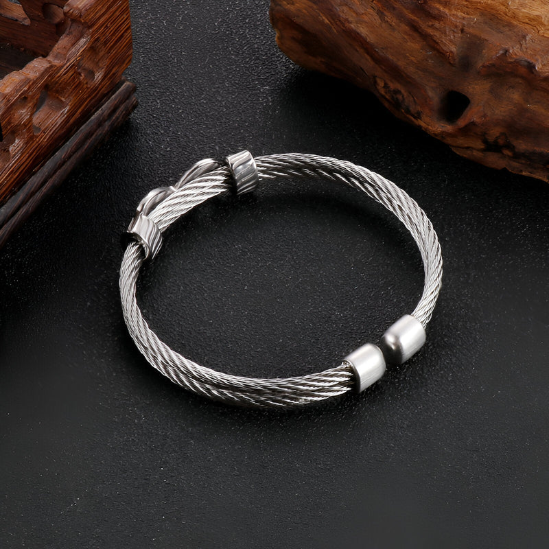Bracelet jonc argenté en acier inoxydable tressé avec motif infini et fermoir métallique lisse.